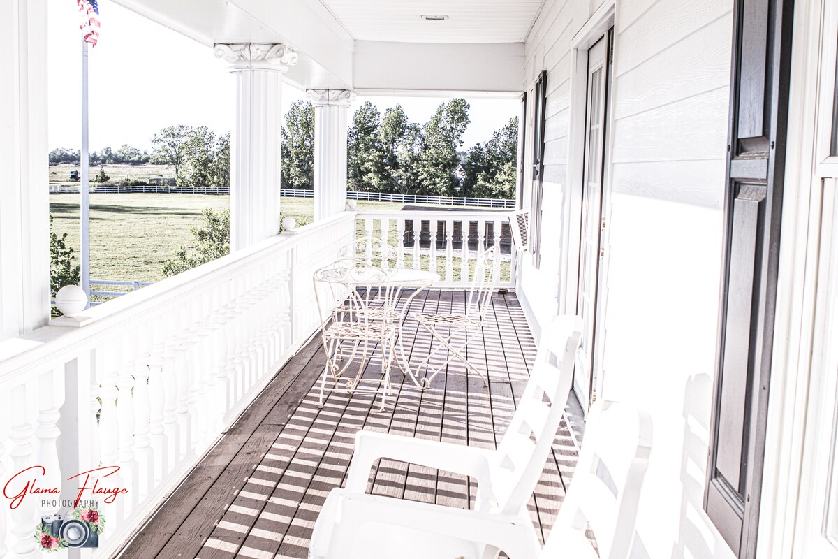 Wraparound porch seating overlooking the pasture at Parkton Place