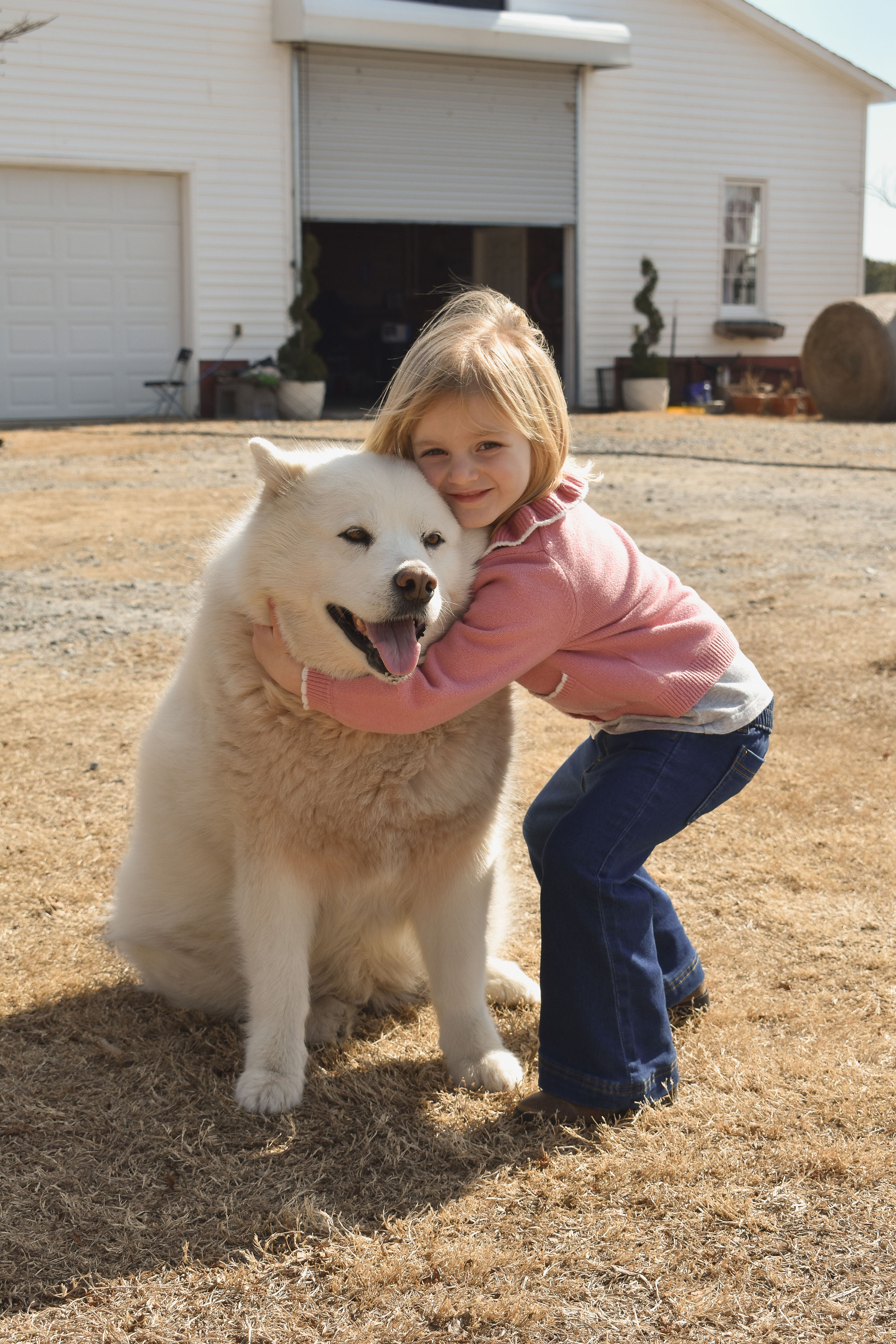 Little girl hugging the farm dog at Parkton Place