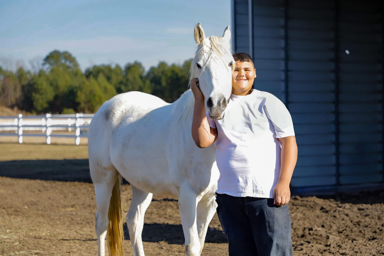 Hope-thru-Horses client standing with a white horse at Parkton Place