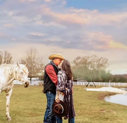 Couple sharing a sunset moment with a horse beside the pond at Parkton Place